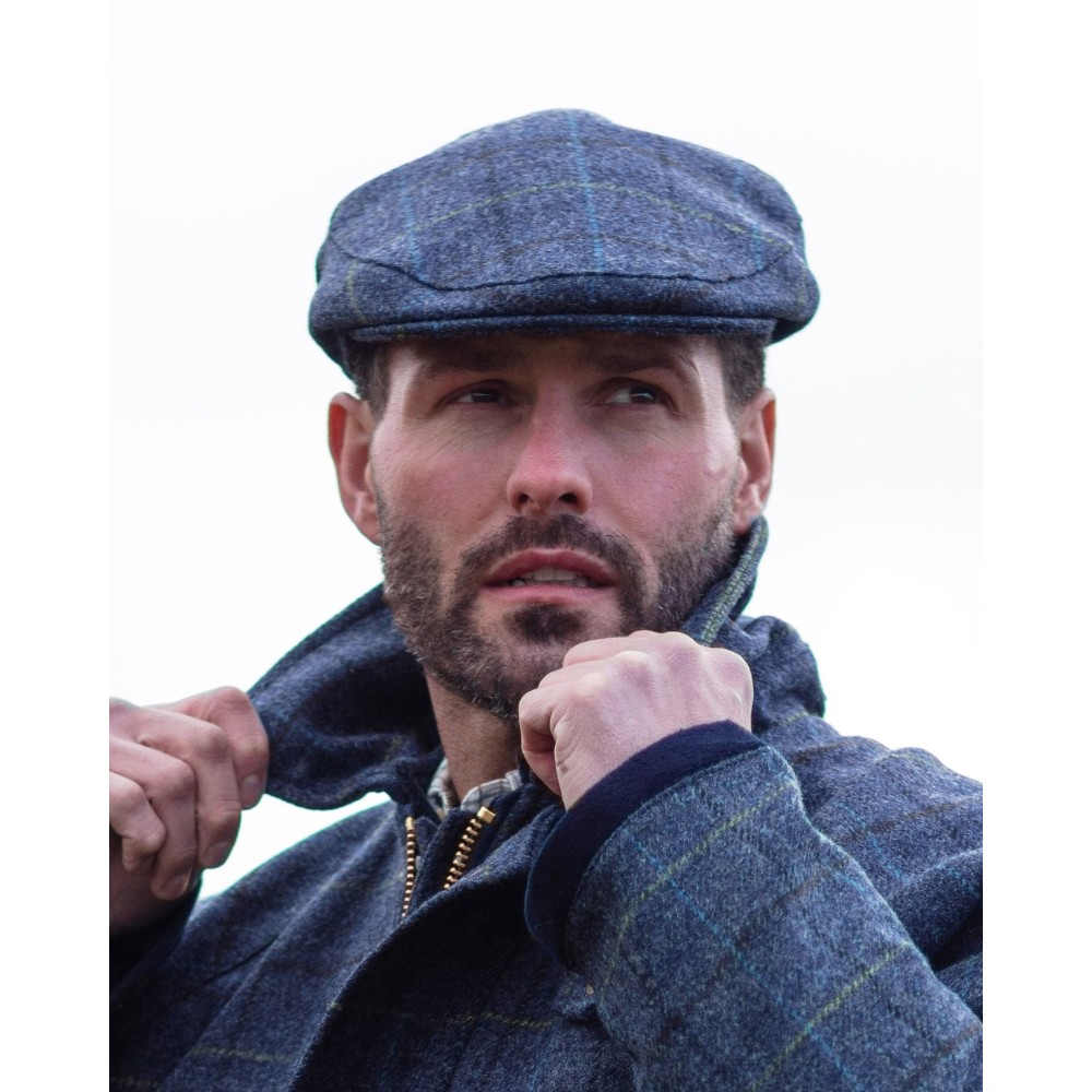 Male model wearing a Walker & Hawkes Alfred cap in navy.