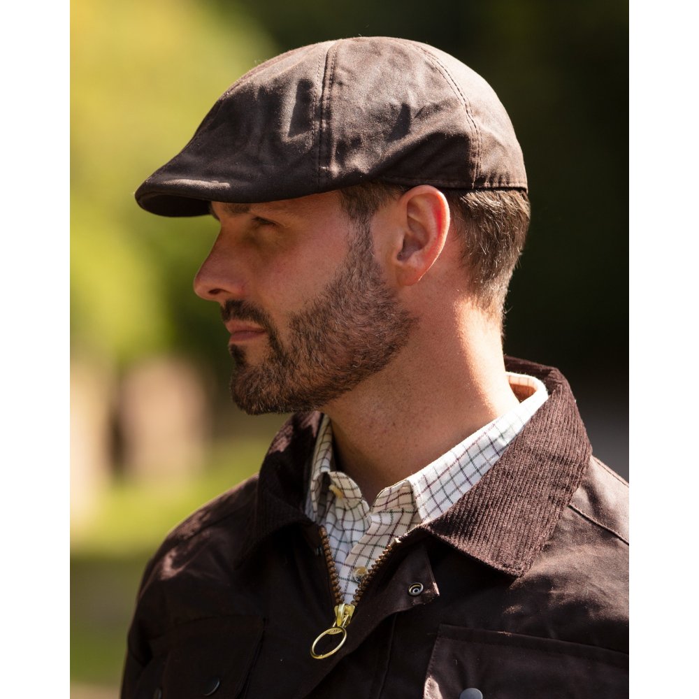 Male model wearing a Walker & Hawkes Bernard duckbill cap in brown.