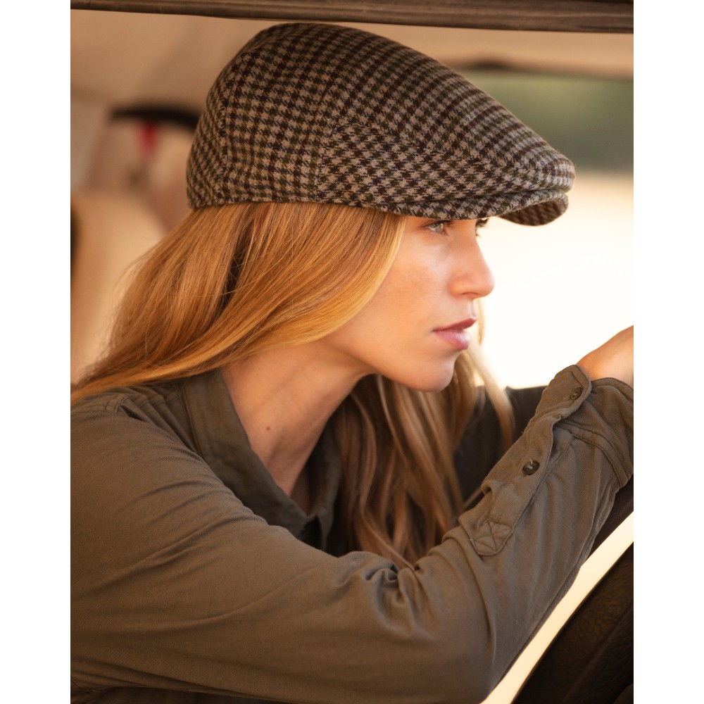 Female model wearing a Walker & Hawkes Braxton flat cap in grey.