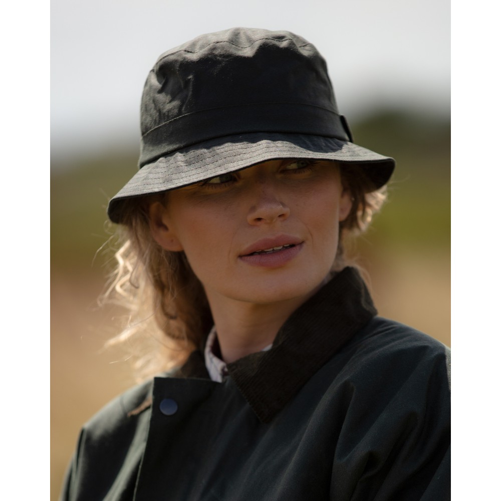 Female model wearing a Walker & Hawkes wax Hanford bucket hat in olive.