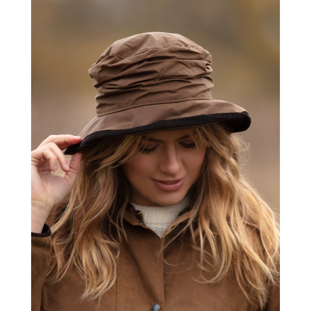 Female model wearing a Walker & Hawkes Diana hat in beige.