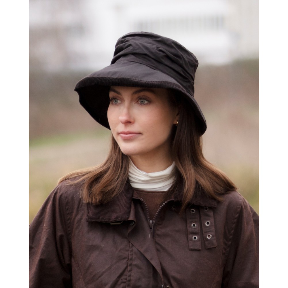 Female model wearing a Walker & Hawkes Diana hat in brown.