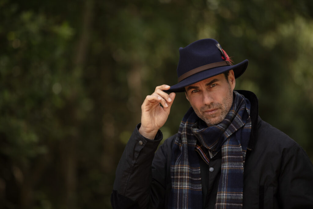 Wearing a navy blue felt hat.