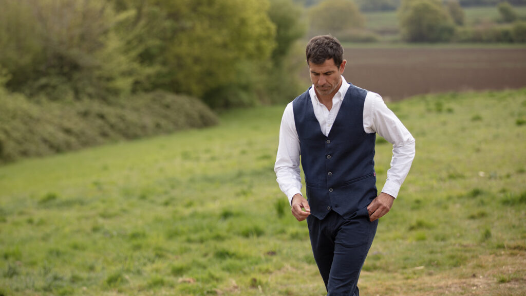 Man walking a field wearing the Baird McNutt Irish Linen Corbet Waistcoat from Walker & Hawkes.