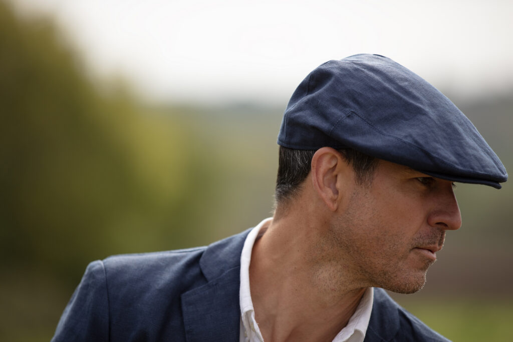 Man wearing a Baird McNutt Irish Linen Beltoy Flat Cap from Walker & Hawkes.