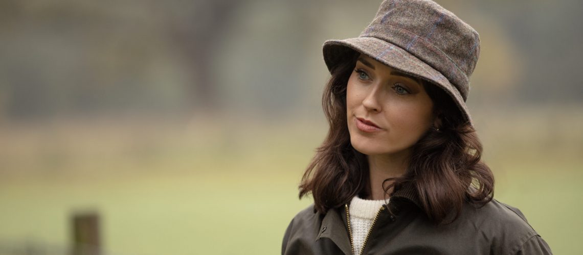 Woman wearing a tweed hat.